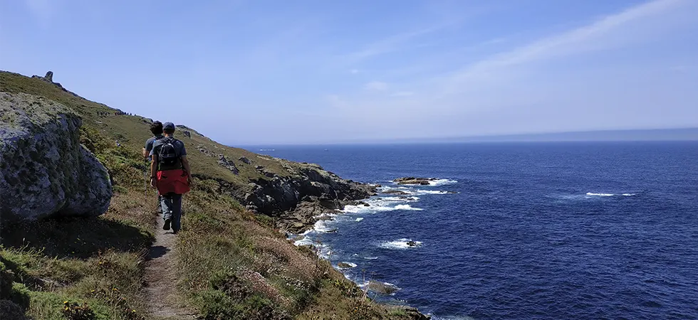 Senderistas recorriendo los acantilados de la Costa da Morte en un dia soleado