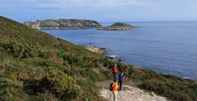 Senderistas en Malpica con las islas sisargas al fondo. Galicia
